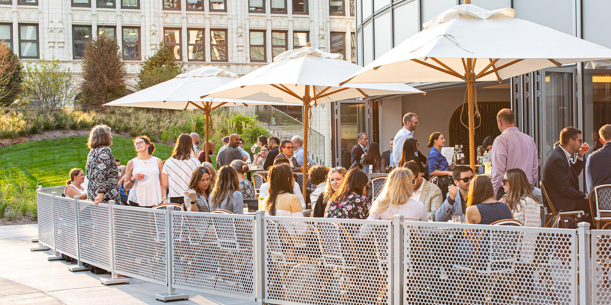 A crowd enjoys an outdoor seating and bar area at Afterbar restaurant