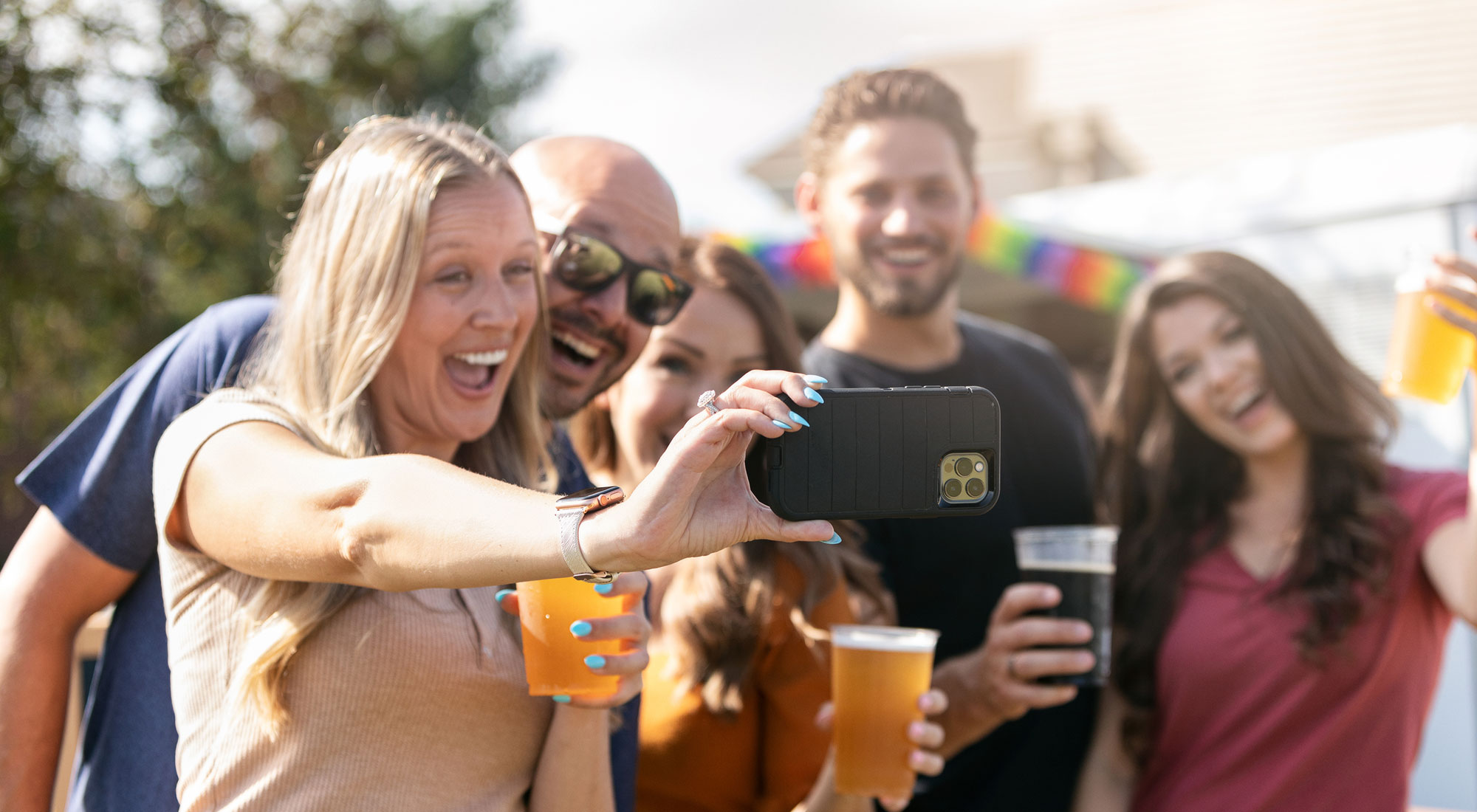 4 friends take a selfie holding drinks
