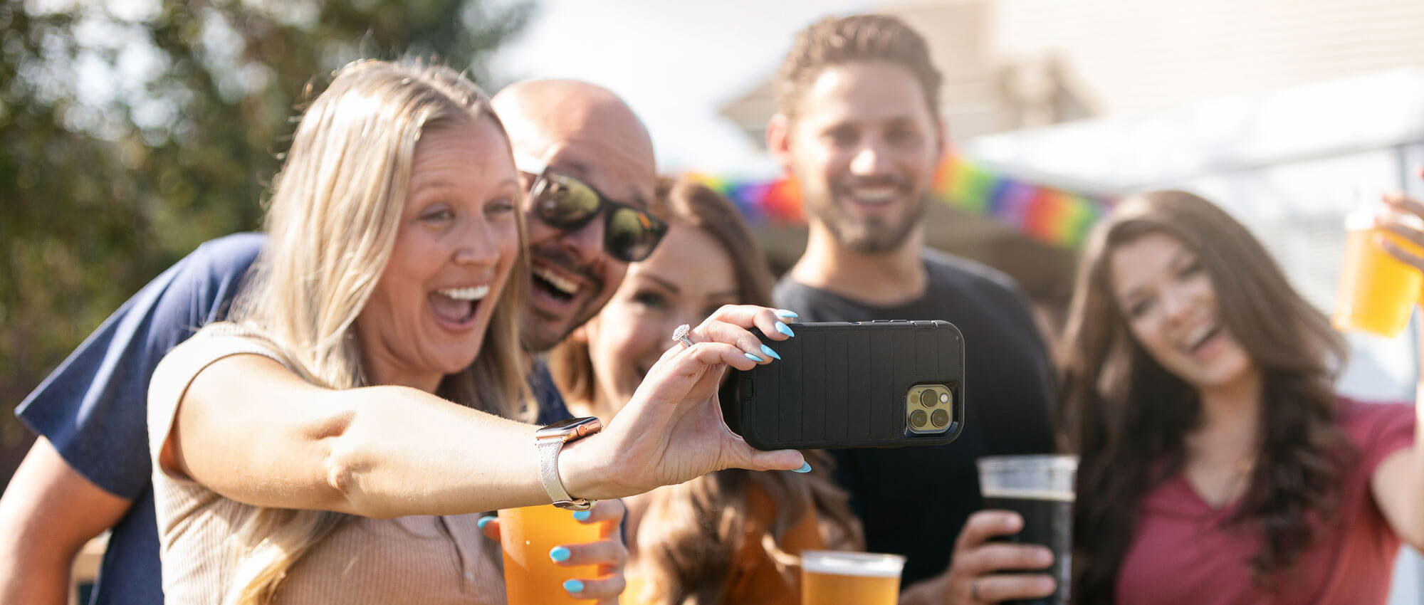 4 friends take a selfie holding drinks